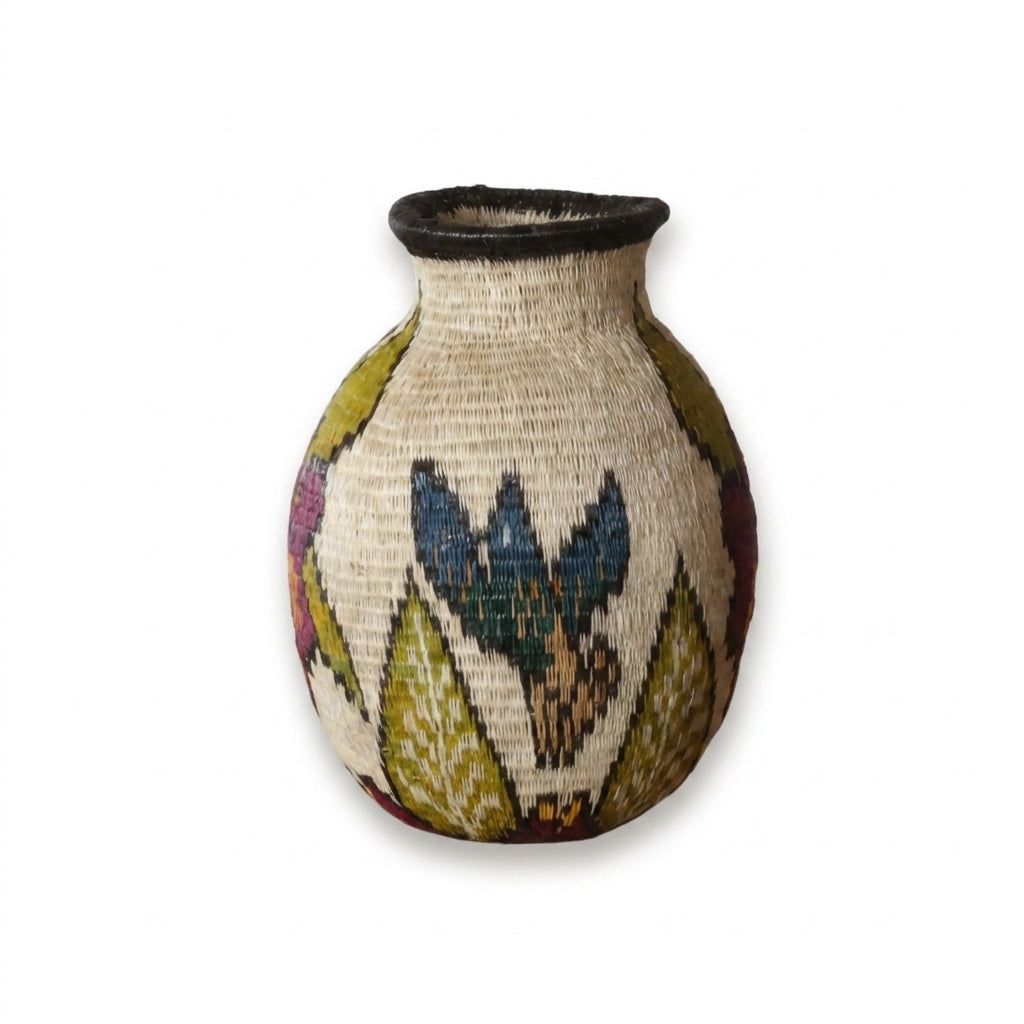 Handwoven Wounaan basket showing indigo-blue bird with spread wings among green leaves on oatmeal weave