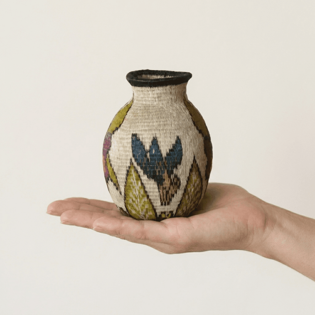 Plum blossom mini handwoven Wounaan basket held in hand showing miniature scale