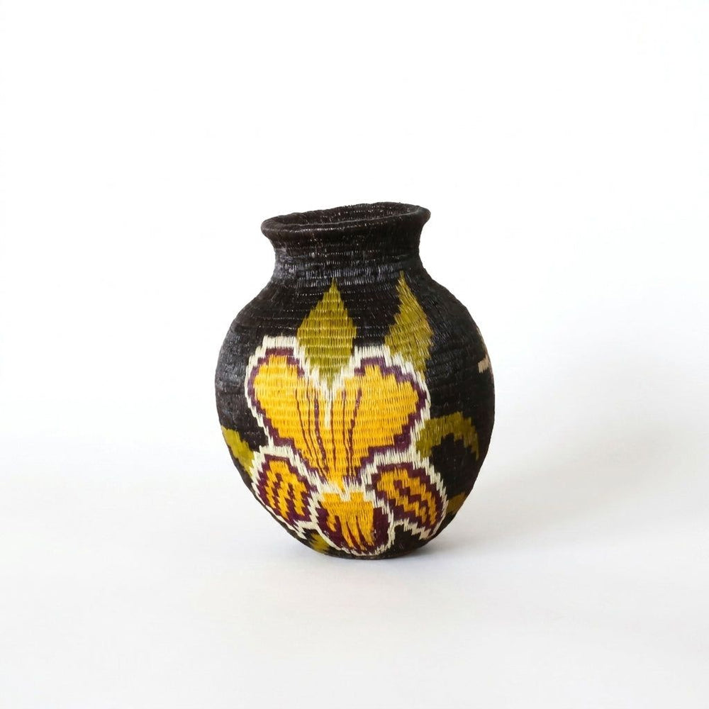 Handwoven Wounaan basket with golden orchid motif in yellow and plum on black, woven art from Darién, Panama