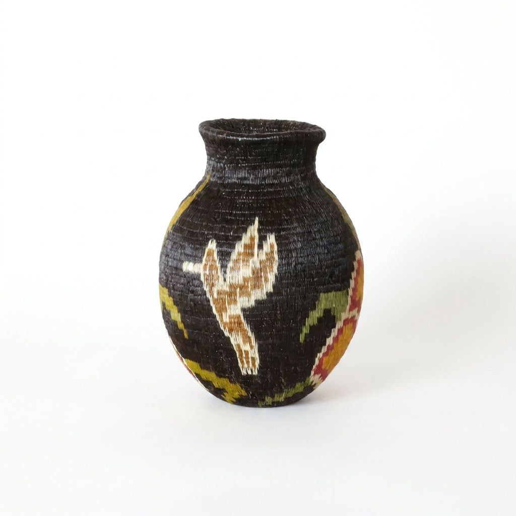 Reverse of handwoven Wounaan basket showing tan hummingbird in flight on dark ground, Panama woven art