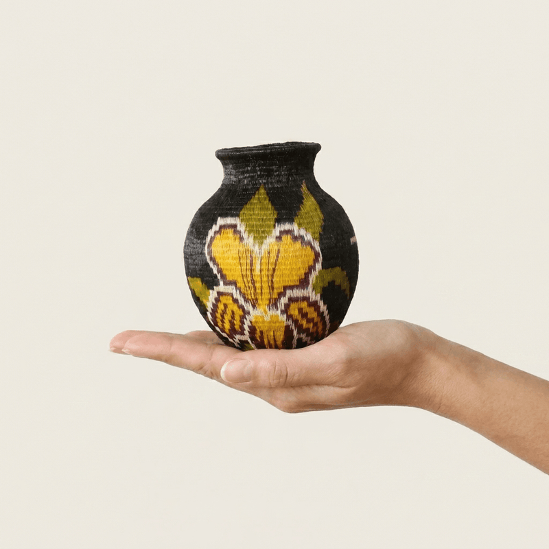 Golden orchid handwoven Wounaan basket held in hand showing miniature scale, about 3 inches wide