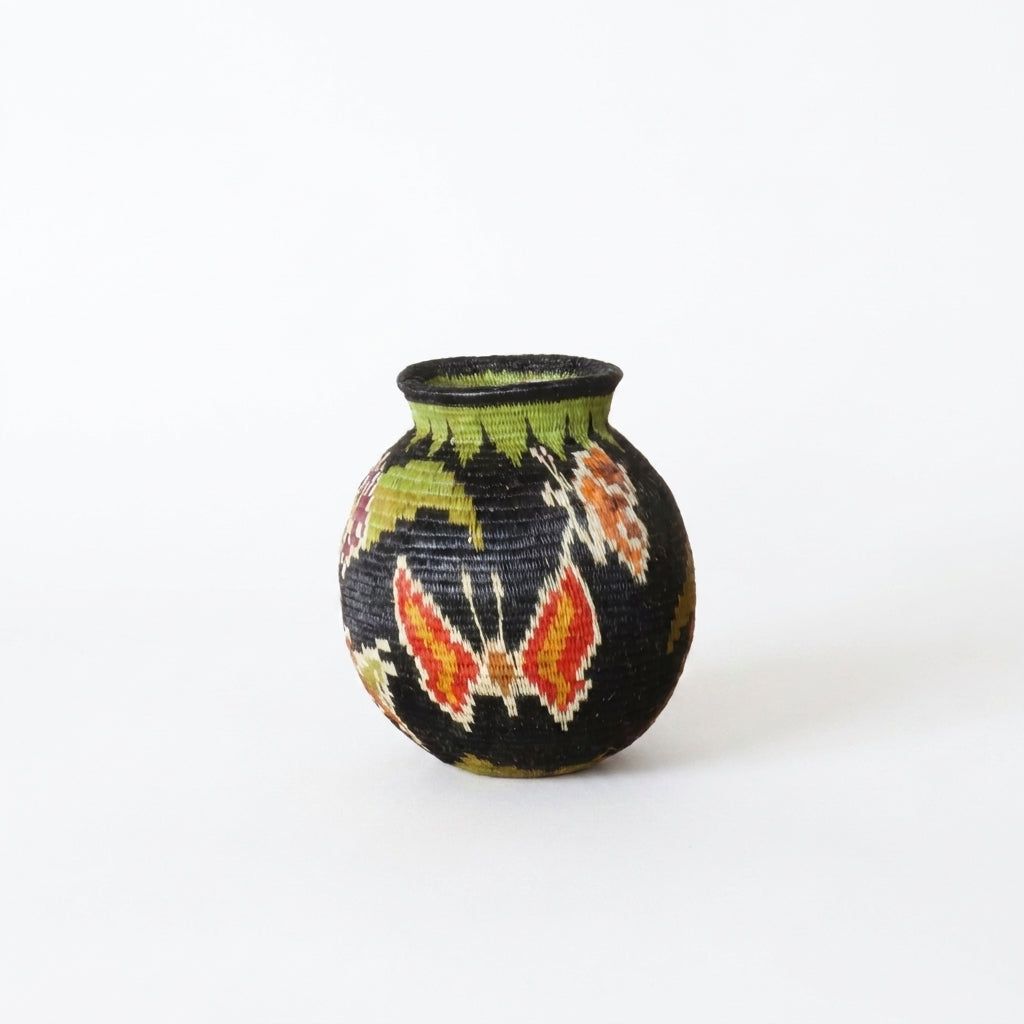Handwoven Wounaan basket showing red-orange butterflies with white outlines on black ground, Darién Panama