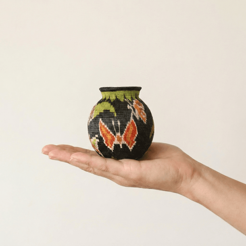 Night garden handwoven Wounaan basket held in hand showing miniature scale, floral and butterfly motif