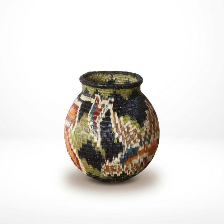 Reverse of tiny handwoven Wounaan basket showing allover blossom pattern in rust, olive, blue and cream
