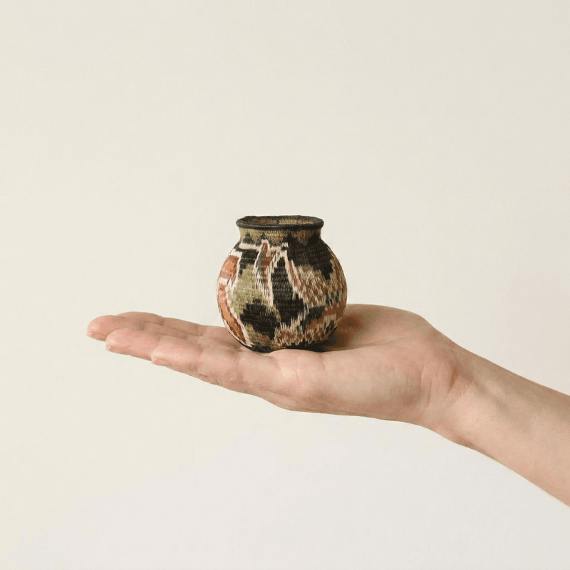 Wildflower handwoven Wounaan basket held in hand showing miniature 2-inch scale, Darién woven art
