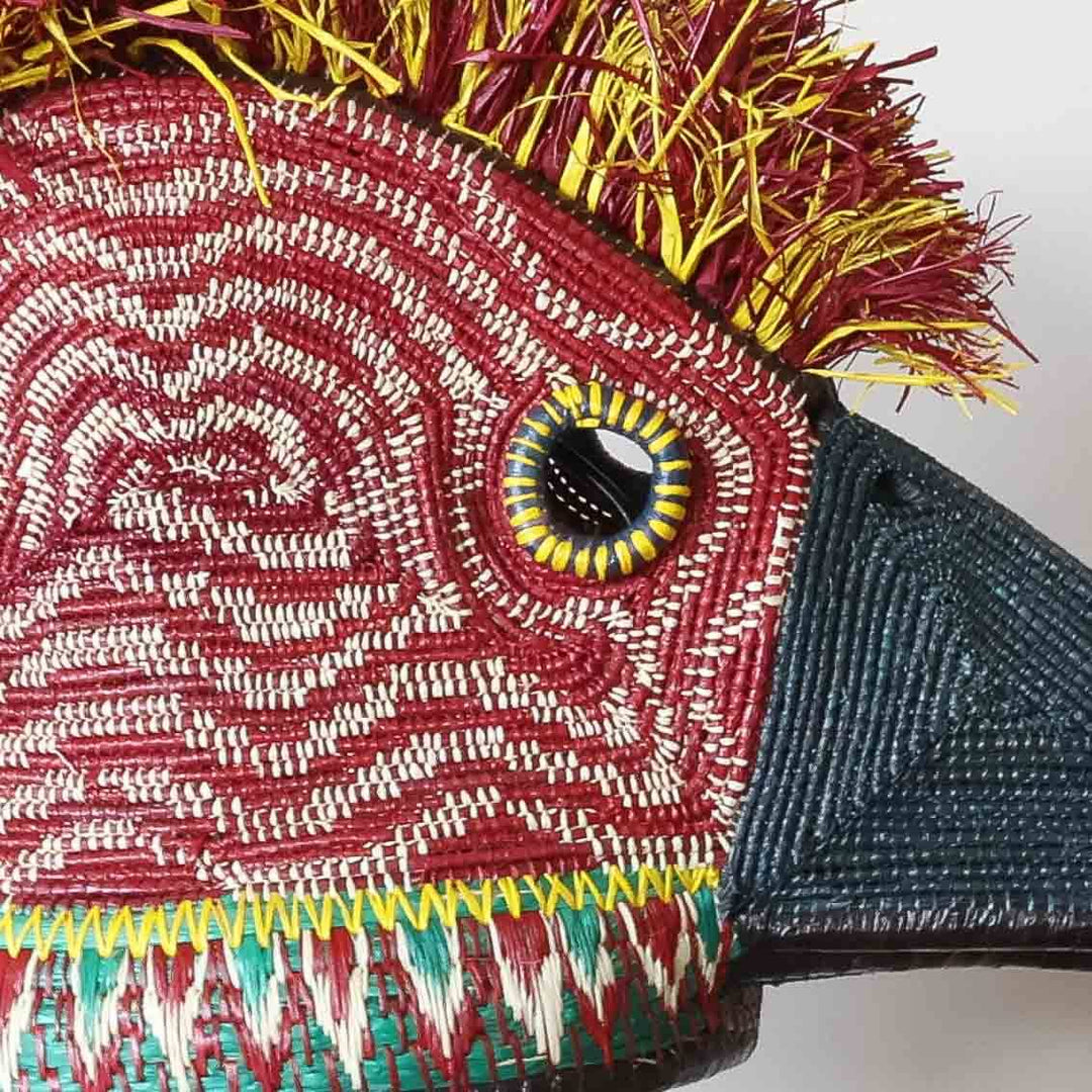 Close-up wavy palm fiber weave pattern detail on red hummingbird ceremonial mask showing Embera craftsmanship