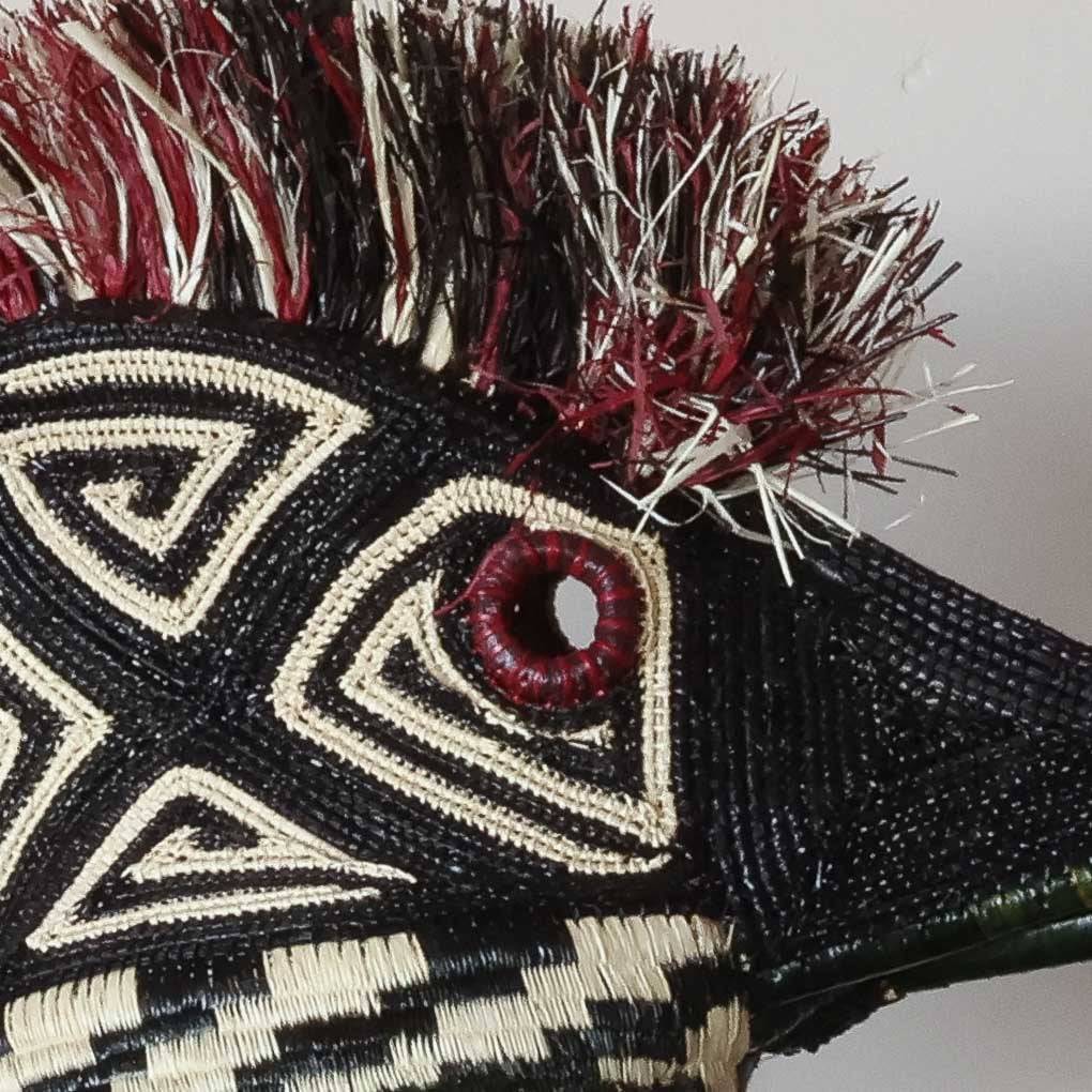 Close-up detail of palm fiber weaving and natural dye work on Embera hummingbird ceremonial mask