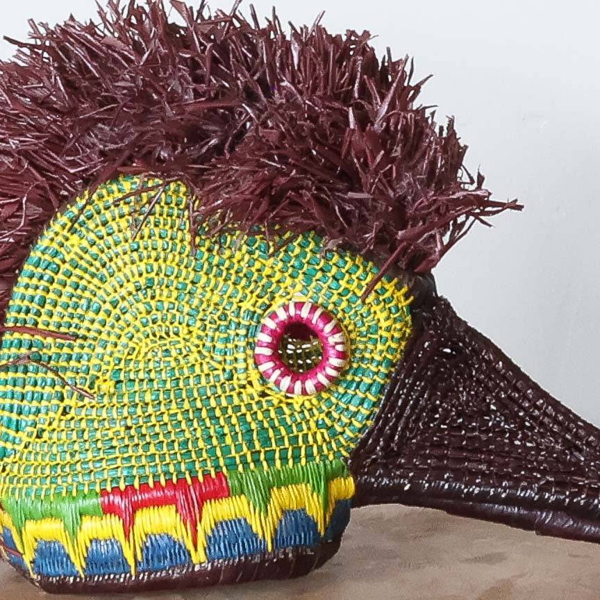 Close-up detail of woven feather patterns and natural green pigments on Embera hummingbird mask