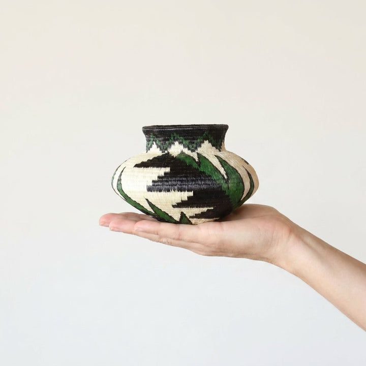 Emerald plume handwoven Wounaan basket held in hand showing miniature scale, about 5 inches wide