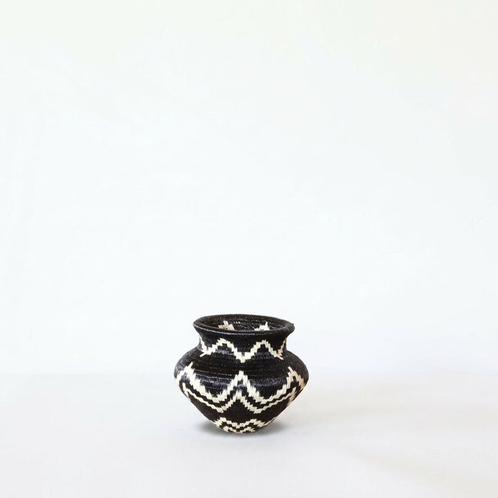 Black and ivory zigzag handwoven Wounaan basket on neutral background, small geometric decorative basket