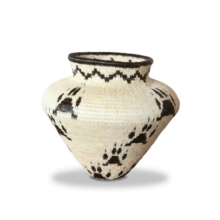 Side view of jaguar paw handwoven Wounaan basket showing brown tracks and zigzag neck band, Darién Panama