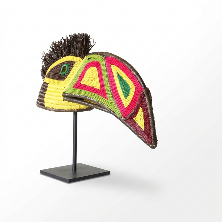 Emberá toucan spirit mask side view, colorful triangle-patterned beak and dark raffia crest, palm fiber
