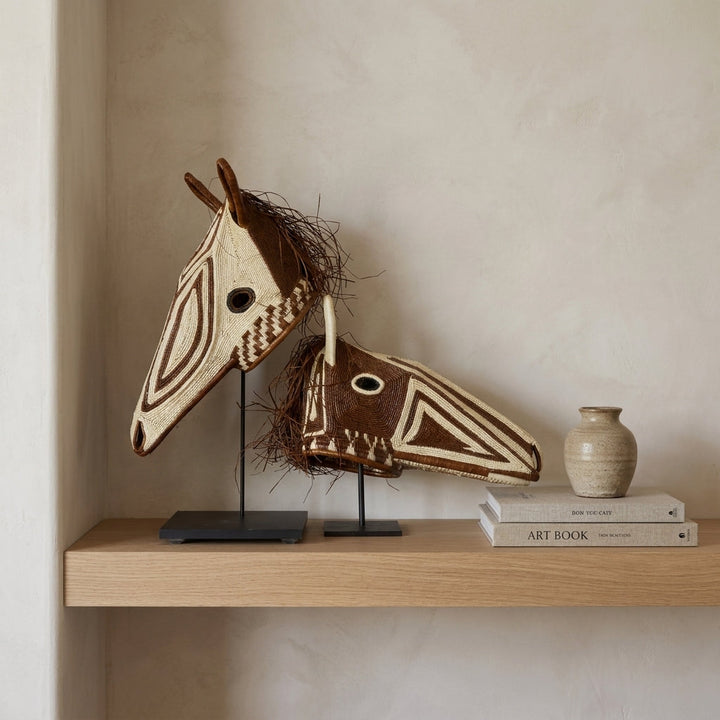 Two Emberá horse masks displayed together on shelf