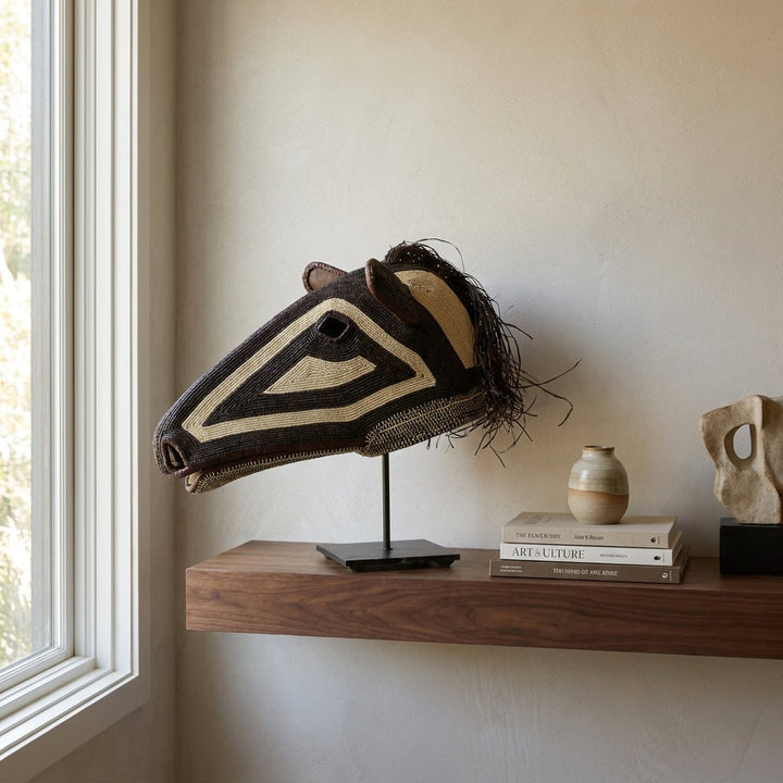 Dark spirit horse mask on shelf, deep brown with ivory triangle eyes, Emberá art