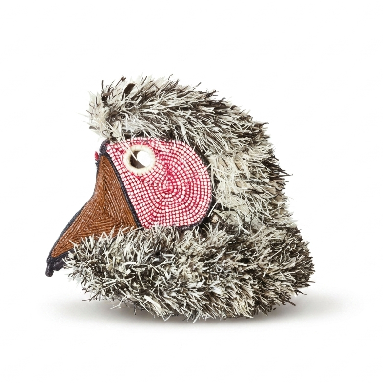 Handwoven Emberá bird mask, grey-and-white raffia plumage with rose-pink beaded face and coppery beak, Panama