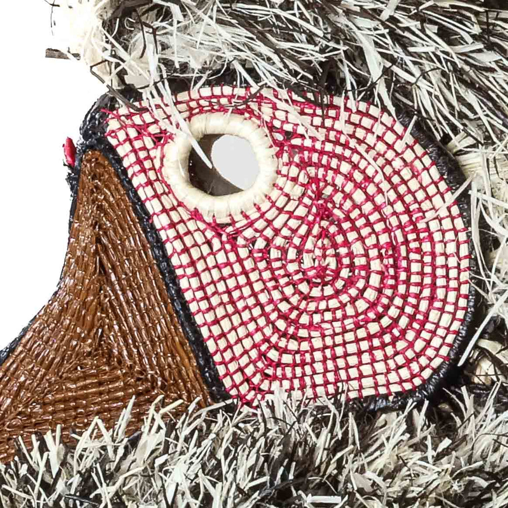 Close-up detail of rose-pink concentric beadwork and brown beaded beak on Emberá bird mask