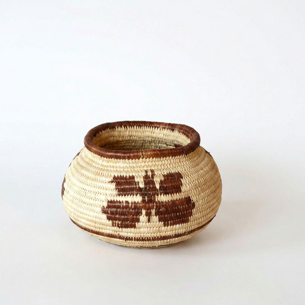 Small handmade basket with vintage brown butterfly pattern woven in palm fiber by indigenous artisan