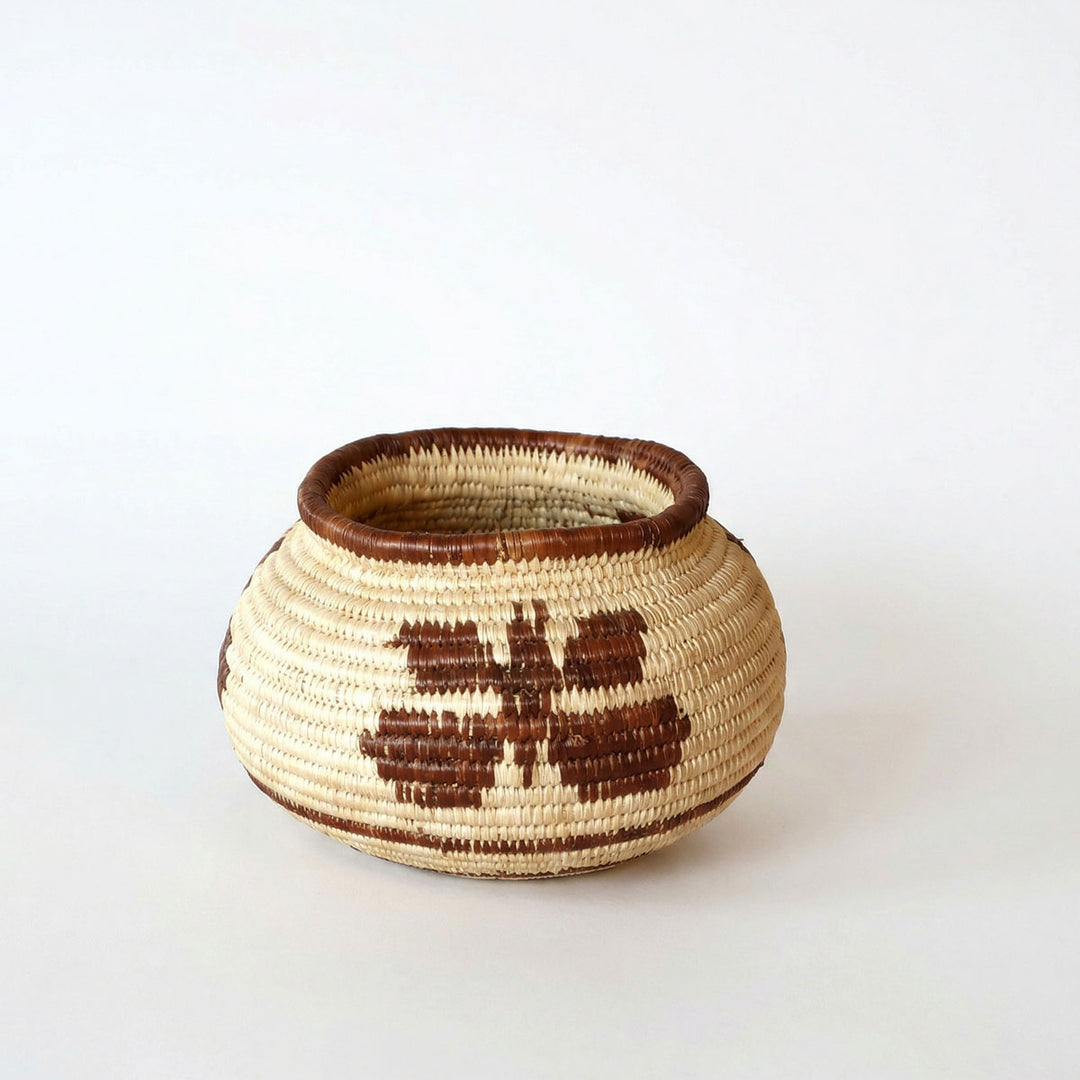 Small handmade basket with vintage brown butterfly pattern woven in palm fiber by indigenous artisan