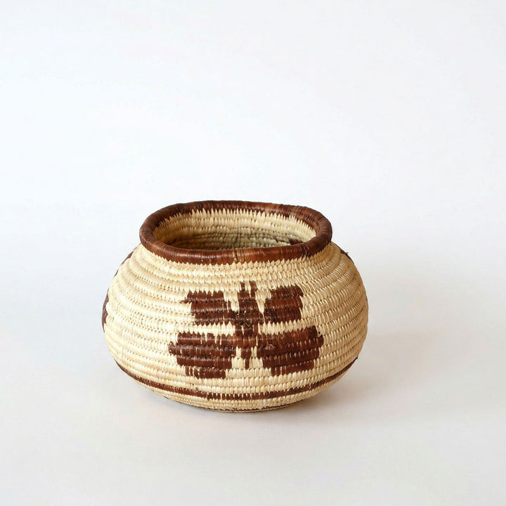 Small handmade basket with vintage brown butterfly pattern woven in palm fiber by indigenous artisan