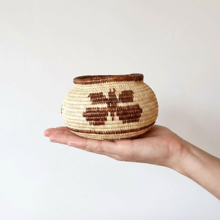 Small handmade basket with vintage brown butterfly pattern woven in palm fiber by indigenous artisan