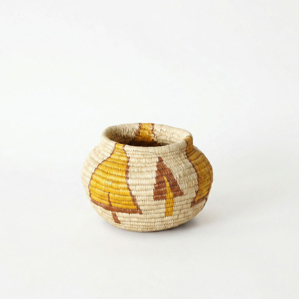 Small handwoven palm fiber basket with golden tree pattern by panama artisans