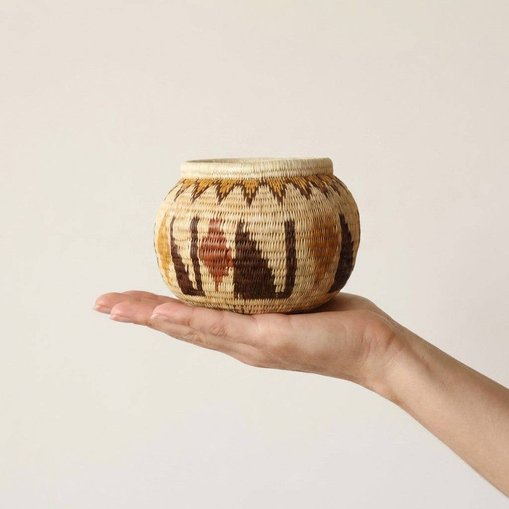 Small crimson woven basket handmade by indigenous artisans with traditional palm fiber weaving