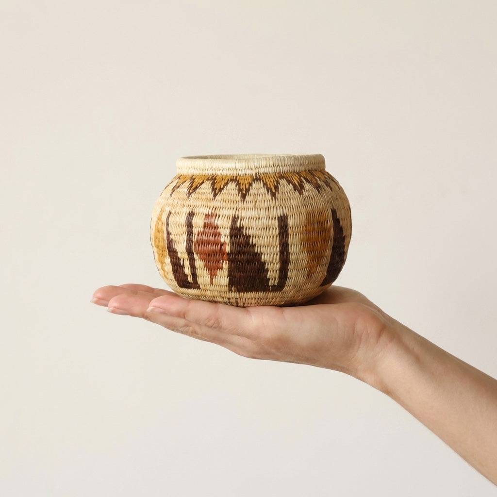 Small crimson woven basket handmade by indigenous artisans with traditional palm fiber weaving
