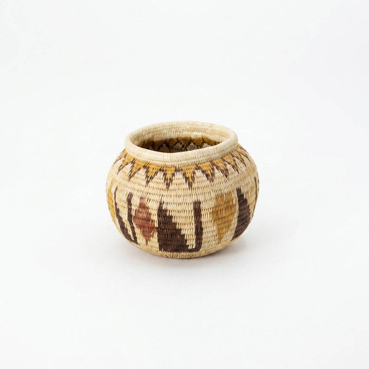 Small crimson woven basket handmade by indigenous artisans with traditional palm fiber weaving