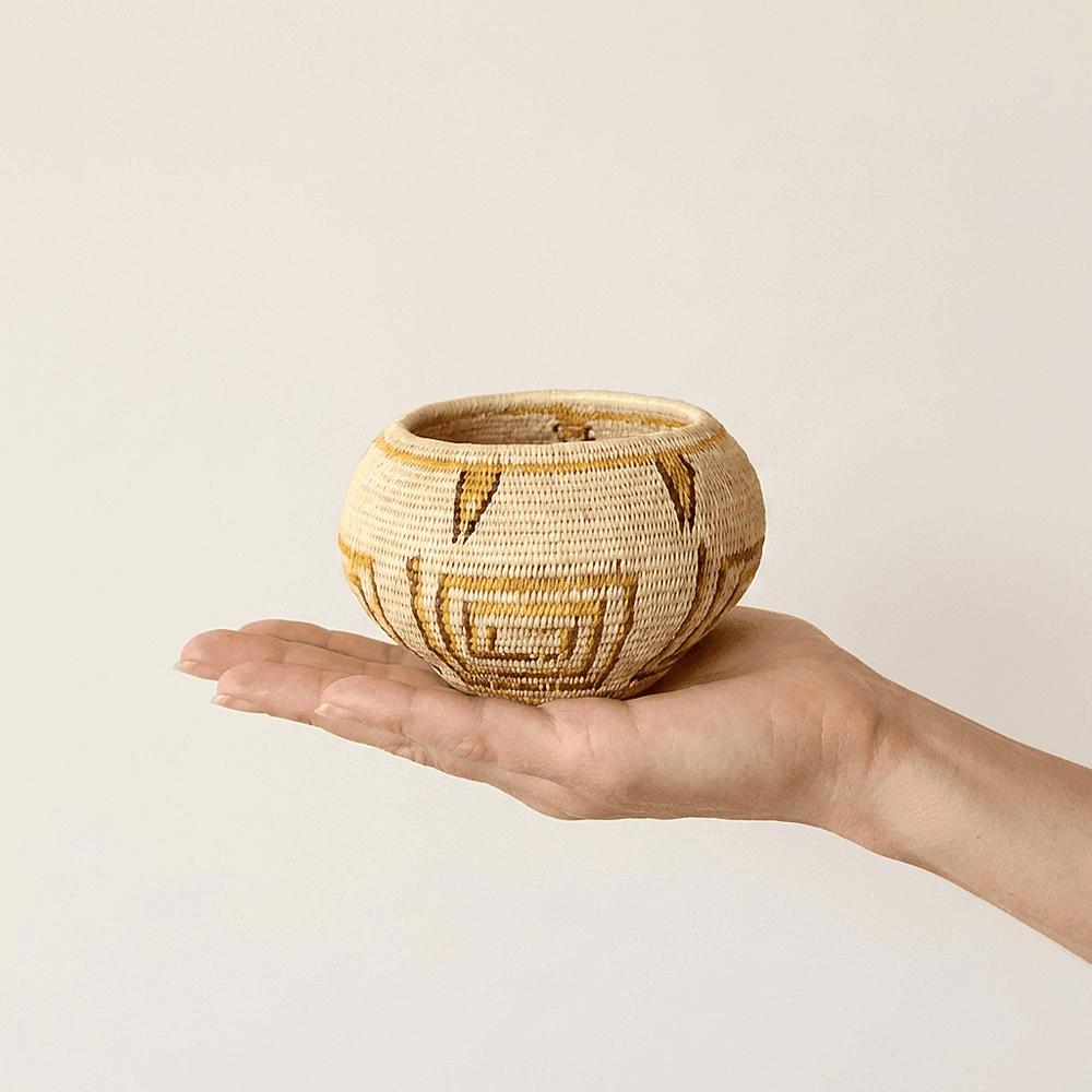 Small handwoven mini basket with golden geometric lines by indigenous artisans