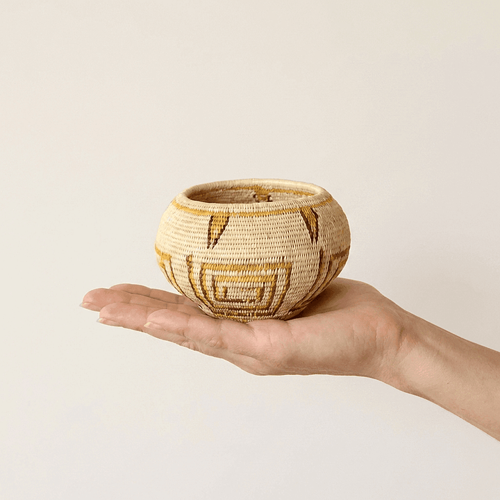 Small handwoven mini basket with golden geometric lines by indigenous artisans