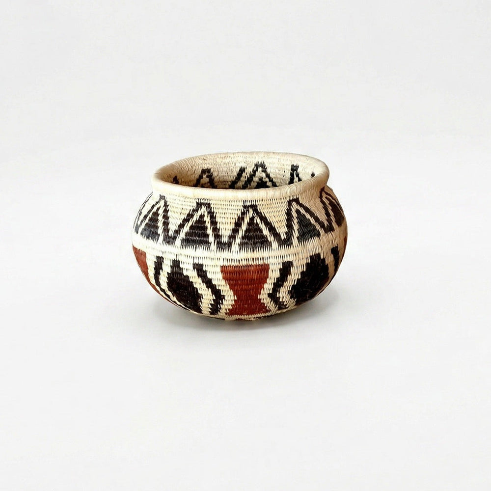 Small handwoven basket with black triangle pattern and lined interior, vintage-style decorative basket