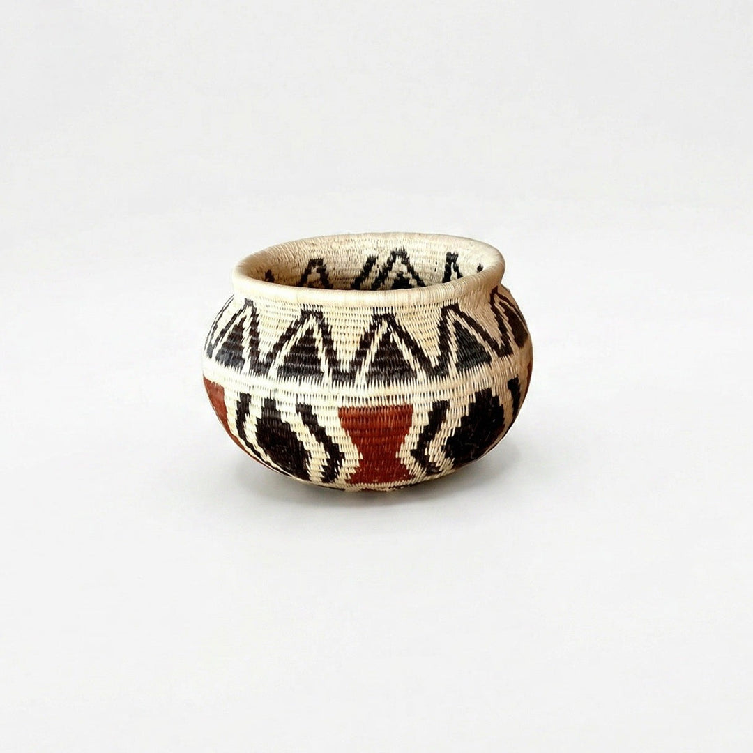 Small handwoven basket with black triangle pattern and lined interior, vintage-style decorative basket