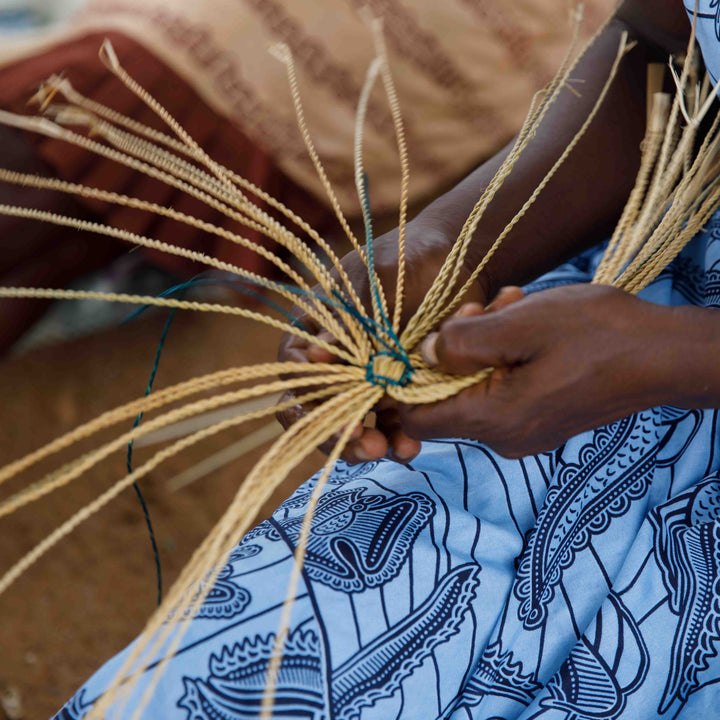Hands of a Bolga weaver binding the starting coil of a new basket, Bolgatanga, Upper East Region, Ghana