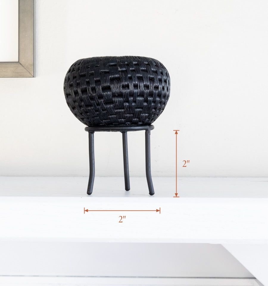 Black metal display stand showcasing handwoven decorative basket, stand 2 inches wide by 2 inches tall