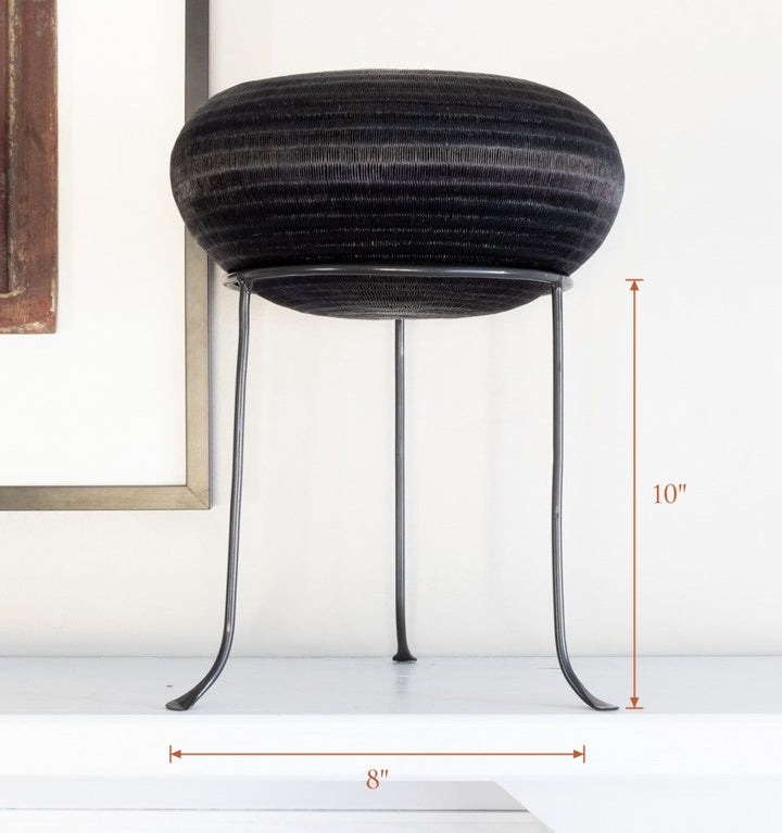 Black metal display stand showcasing handwoven decorative basket, stand 8 inches wide by 10 inches tall